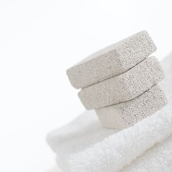 Pumice stones on towels against a white background.