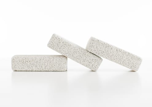 Pumice stones against a white background, sleight reflection.