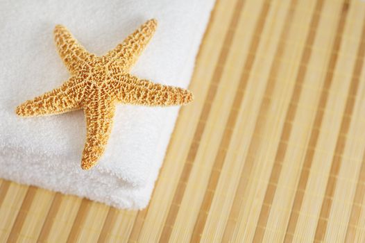 Starfish and towels on a bamboo mat.