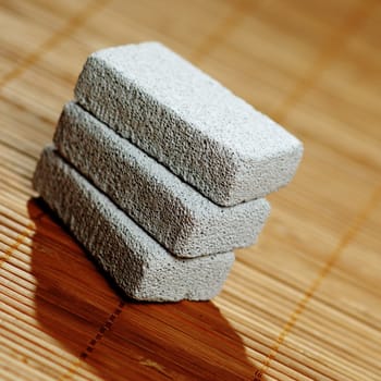Stack of pumice stones on top of a bamboo mat.