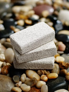 Pumice stones on display on top of river rocks.