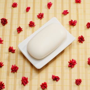 Soap dish with soap on top of a bamboo mat.