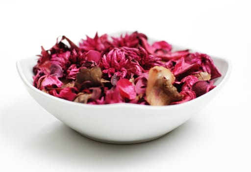 Potpourri in a white bowl against a white background.