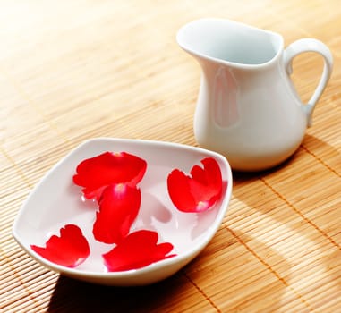 Pitcher, water, and floating rose petals
