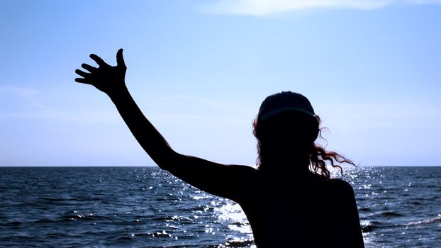 Silhouette of woman against the sea in the evening