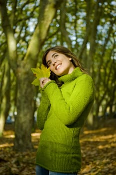 Portrait of a beautiful young woman holding a leaf