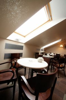 White tables and brown chairs in modern cafe