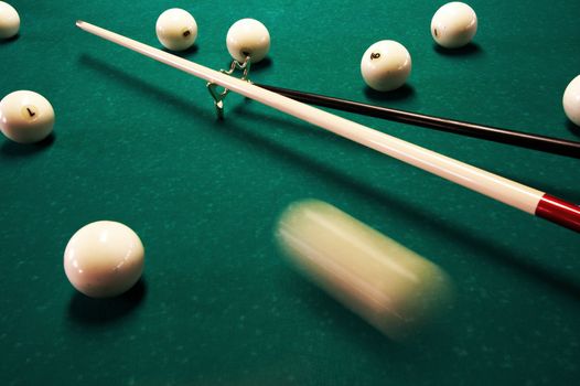 White spheres and cue on a green billiard table
