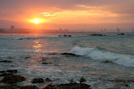 Beautiful sunset over the ocean with city in background