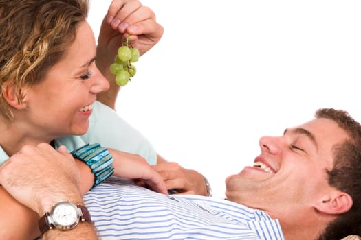 Boy holding grapes in front of his girlfriends face
