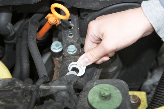 Woman hand turning one of the screws inside a car