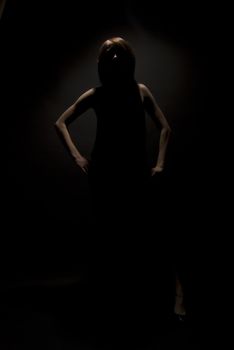 Portrait of a young beautiful girl in darkness