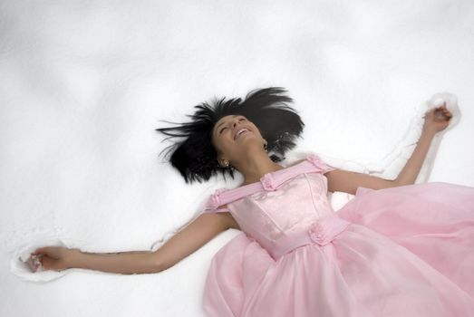 young bride in pink wedding dress resting on the snow