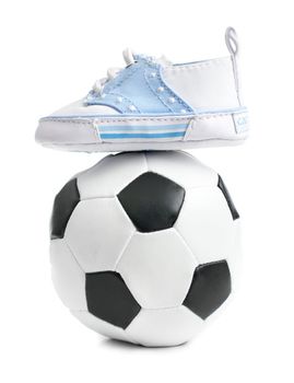 A football / soccer ball with baby shoes, on white.