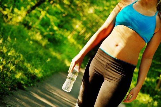 Young woman working out on a forest path.