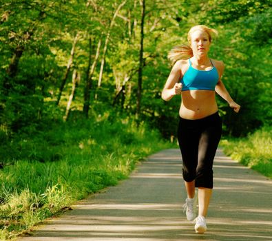 Young woman working out on a forest path.