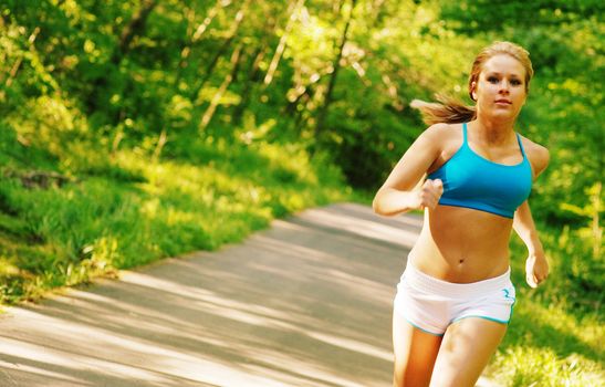 Young woman working out on a forest path.