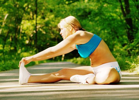 Young woman working out on a forest path.