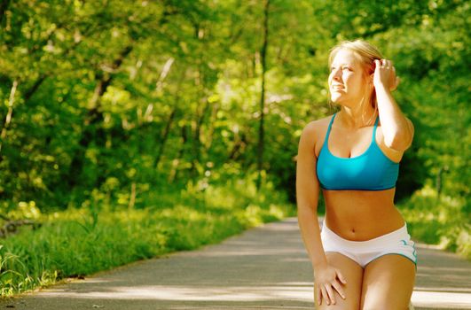 Young woman working out on a forest path.