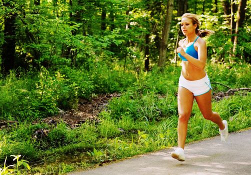 Young woman working out on a forest path.