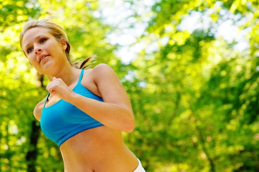 Young woman working out on a forest path.