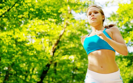 Young woman working out on a forest path.