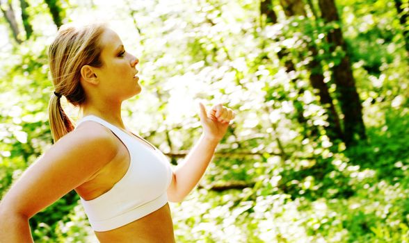 Young woman working out on a forest path.