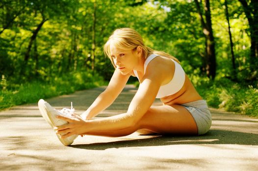 Young woman working out on a forest path.