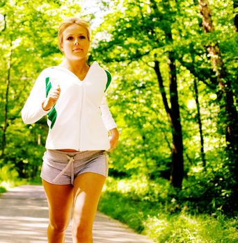 Young woman working out on a forest path.