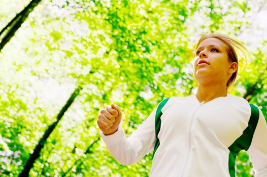 Young woman working out on a forest path.