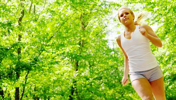 Young woman working out on a forest path.