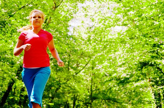 Young woman working out on a forest path.