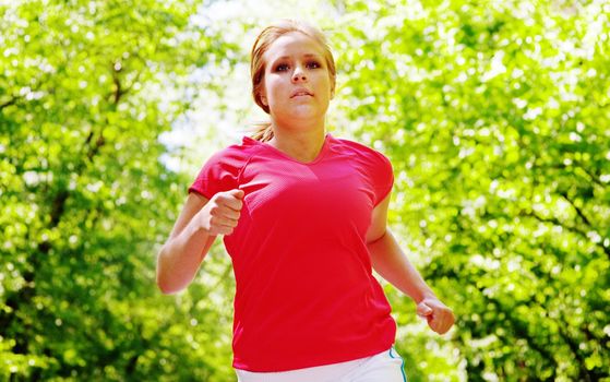 Young woman working out on a forest path.