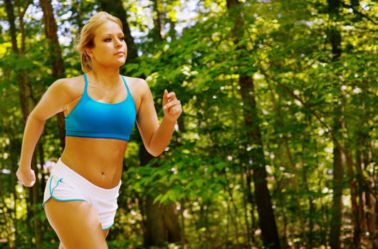 Young woman working out on a forest path.