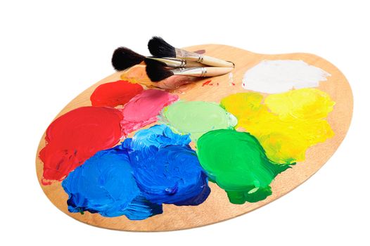 Three paintbrush on the palette with bright acrylic paints
