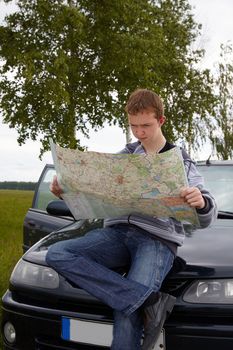 Traveling. Young driver with maps