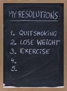 numbered resolution lists (quit smoking, exercise, loose weight, ...) - handwriting with white chalk on small blackbard, copy space