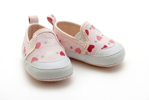 A pair of baby girls shoes on white background.