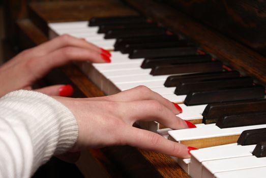 A macro shot of a woman playing the piano.
