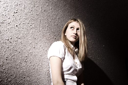 Portrait of a young pretty blonde on the wall background