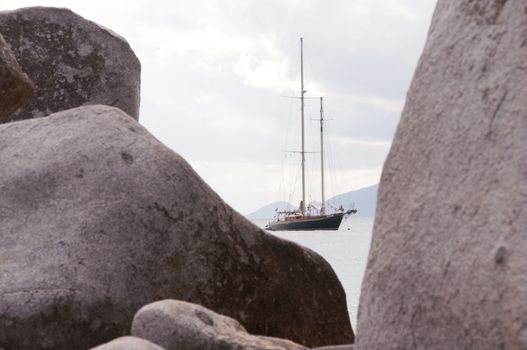 Large schooner anchored in a bay framed by granite boulders.