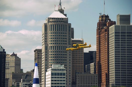 Three vintage Royal Canadian Air Force planes flying past the city of detroit during the Red Bull Air Race.