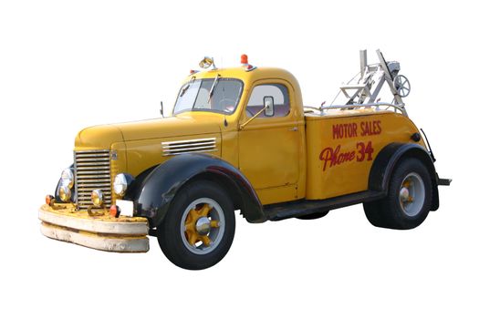 This is a 1940's yellow wrecker tow truck with black fenders for a used car, motor sales company, isolated on a white background.