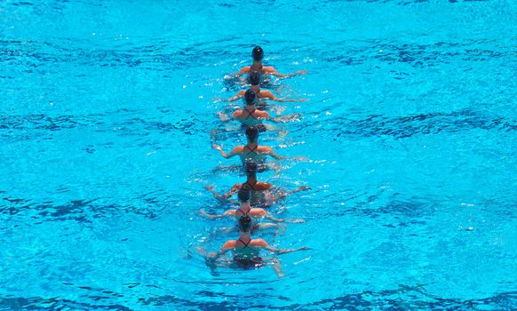 A seven women synchronized swimming team performing.