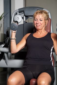 Mature woman working out on the fitness machines