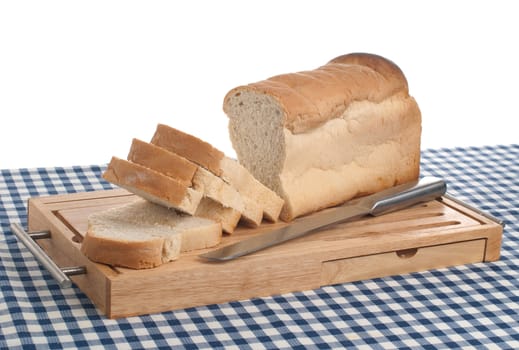 Slices of bread on top of wooden board and a blue square pattern towel.