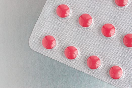 Macro of medical pills on a silver background.