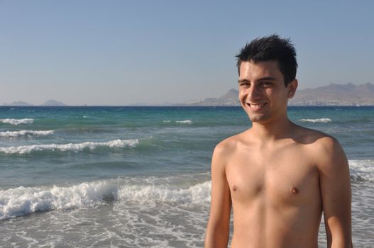 handsome young man getting suntan at Kos beach in Greece (blue sky)