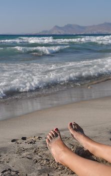 woman feet lying and relaxing on the beach