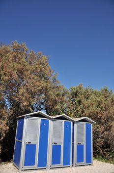 blue portable toilets near the beach